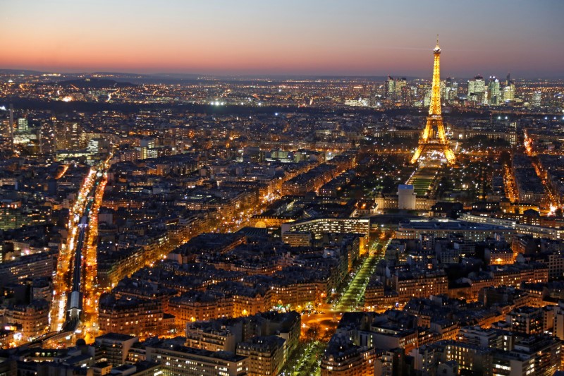 © Reuters. A general view shows the illuminated Eiffel Tower and rooftops at night in Paris