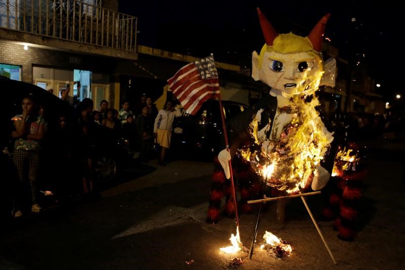 © Reuters. حرق دمى تمثل ترامب في جواتيمالا لطرد الأرواح الشريرة