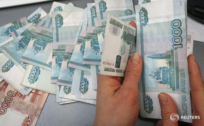 © Reuters. Сотрудник частного магазина в Красноярске пересчитывает деньги