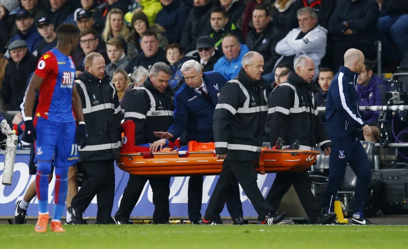 © Reuters. Crystal Palace's Connor Wickham is stretchered off after sustaining a serious injury as manager Alan Pardew consoles him