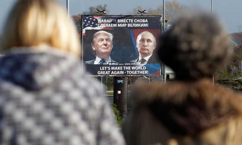 © Reuters. A  billboard showing a pictures of US president-elect Donald Trump and Russian President Vladimir Putin is seen through pedestrians in Danilovgrad