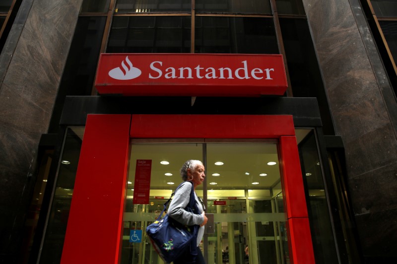 © Reuters. A woman walks past a Banco Santander branch in downtown
