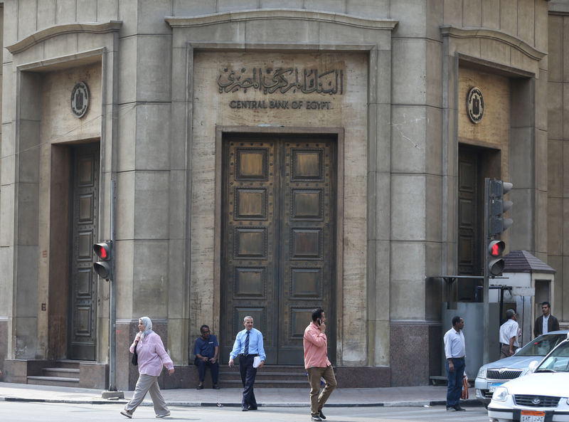© Reuters. People walk in front of the Central Bank of Egypt's headquarters at downtown Cairo