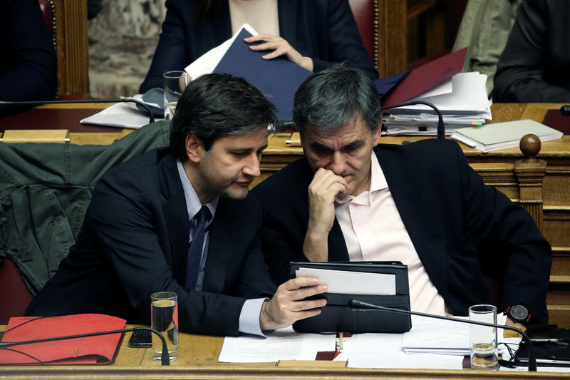 © Reuters. Greek Finance Minister Tsakalotos and Alternate Finance Minister Chouliarakis look at their notes during a parliamentary session before a budget vote in Athens