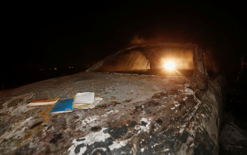 © Reuters. A motorist drives past the wreckage of a car burnt after a fireball from an tanker engulfed several vehicles and killed several people, near the Rift Valley town of Naivasha, west of Kenya's capital Nairobi