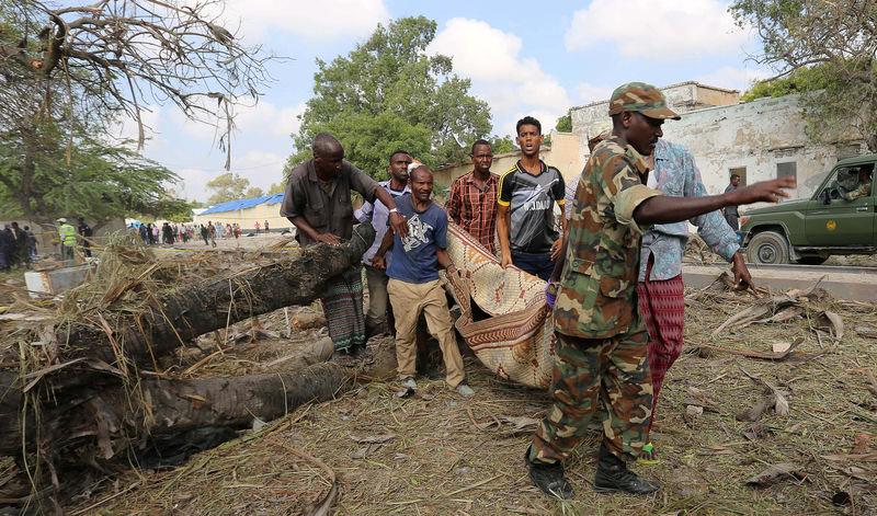 © Reuters. Residents carry the dead body of a man killed after a suicide car bomb went off at the entrance of Somalia's biggest port in the capital Mogadishu