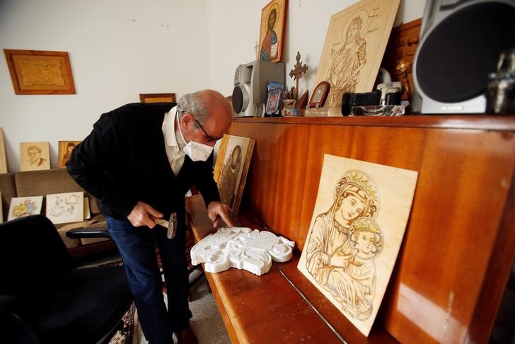 © Reuters. Christian artist and sculptor Naser Jeldha crafts a sculpture in his studio in Gaza City