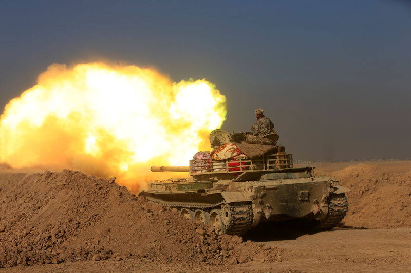 © Reuters. Members of the Iraqi Army fire towards Islamic State militant positions at the south of Mosul