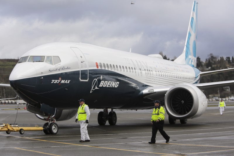 © Reuters. Ground crew members escort a Boeing 737 MAX as it returns from a flight test at Boeing Field in Seattle, Washington