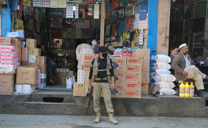 © Reuters. A policeman stands guard at a market in Mingora, in Swat Valley
