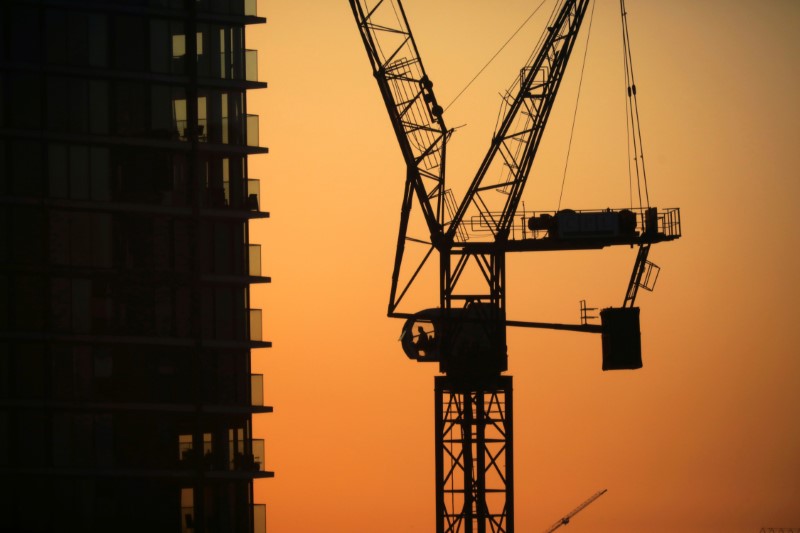 © Reuters. Cranes are seen on a construction site in London's financial district of Canary Wharf