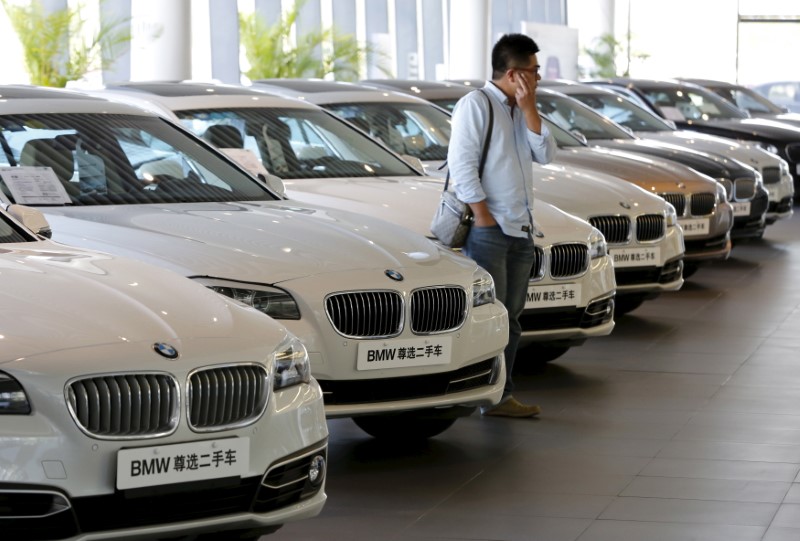 © Reuters. A man takes a look at second-hand BMW cars at a dealer shop in Beijing