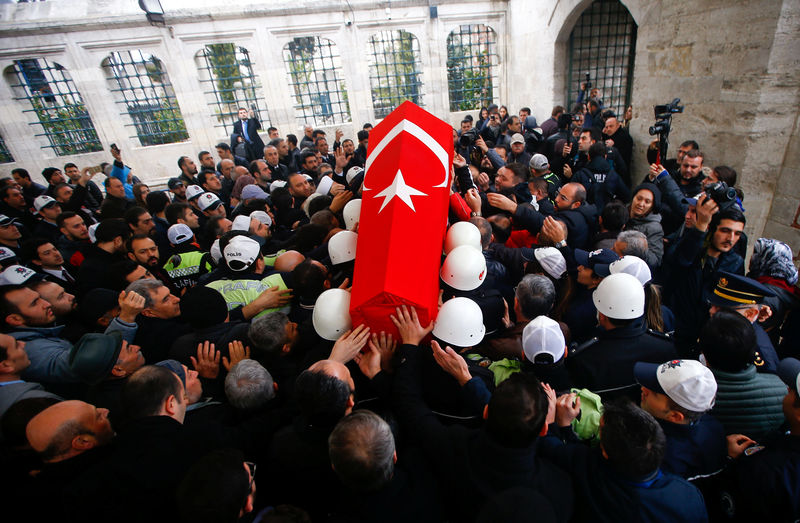 © Reuters. Relatives and friends carry flag-wrapped coffin of police officer Hasim Usta who was killed in Saturday's blasts, during a funeral ceremony in Istanbul