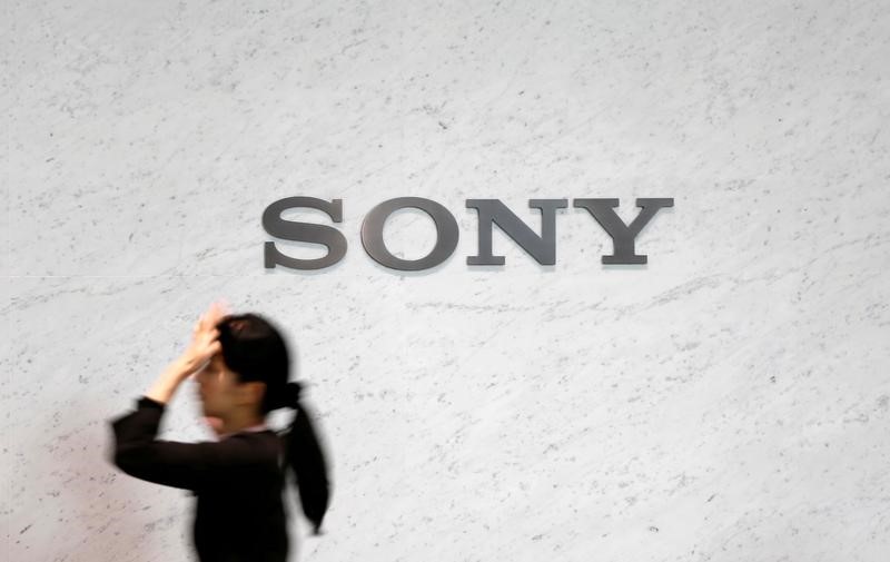 © Reuters. A reception staff walks under a logo of Sony Corp at its headquarters in Tokyo