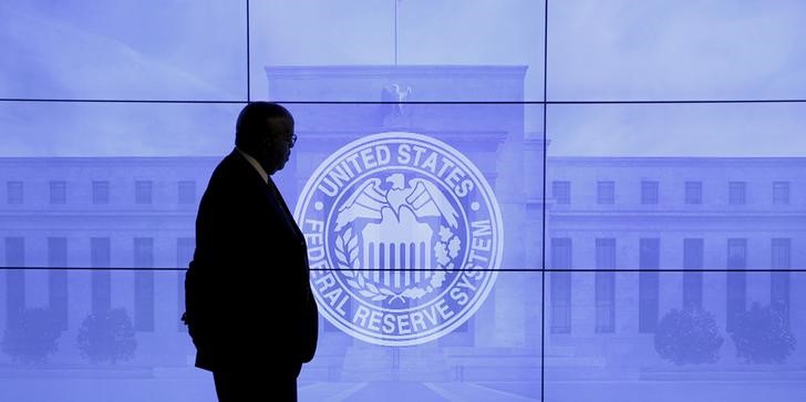 © Reuters. Охранник на фоне изображения здания и логотипа ФРС США перед пресс-конференцией в Вашингтоне