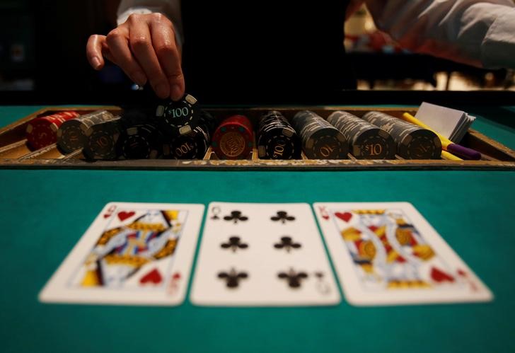 © Reuters. Crupiê entrega fichas durante jogo de Black Jack durante evento em Tóquio