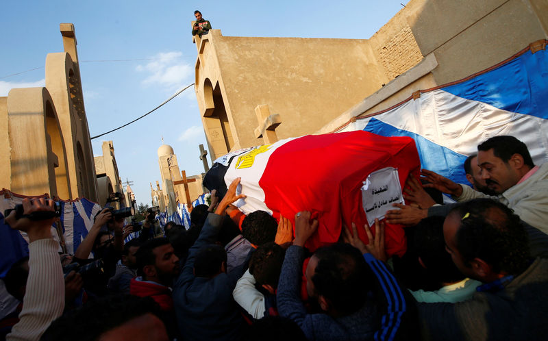 © Reuters. Relatives of Ensaf Adel, a Christian woman who was killed in the bombing of Cairo's main Coptic cathedral, carry her body to bury her at the Mokattam Cemetery in Cairo