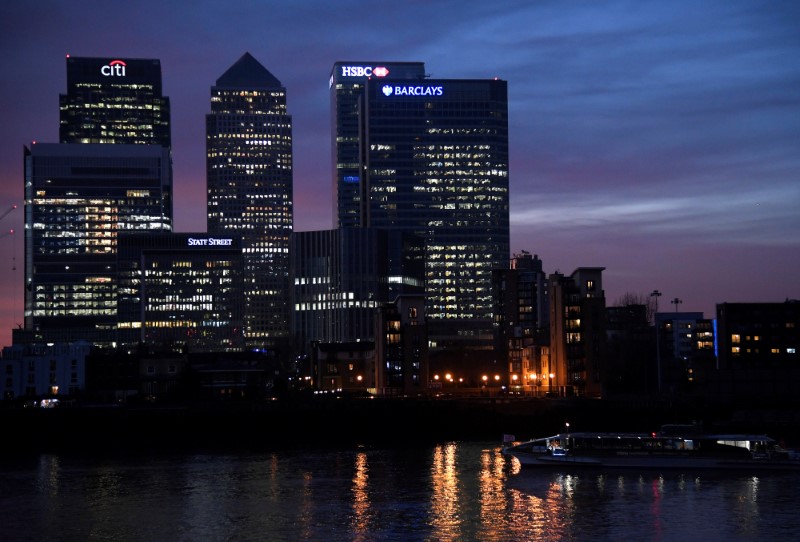© Reuters. A river ferry passes in front of the Canary Wharf business district at dusk in London