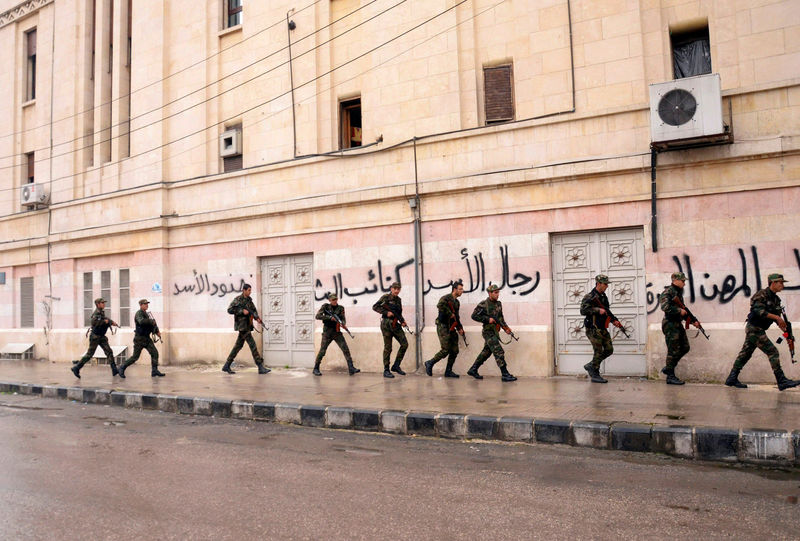 © Reuters. Soldiers loyal to Syrian President Bashar al-Assad patrol the streets in al-Sabaa Bahrat district, an area controlled by Free Syrian Army fighters, in Aleppo