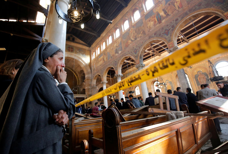 © Reuters. A nun cries as she stands at the scene inside Cairo's Coptic cathedral, following a bombing, in Egypt