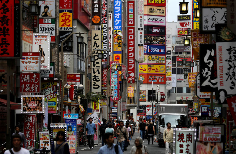 © Reuters. People walk through a street in Tokyo's Shinjuku district, Japan
