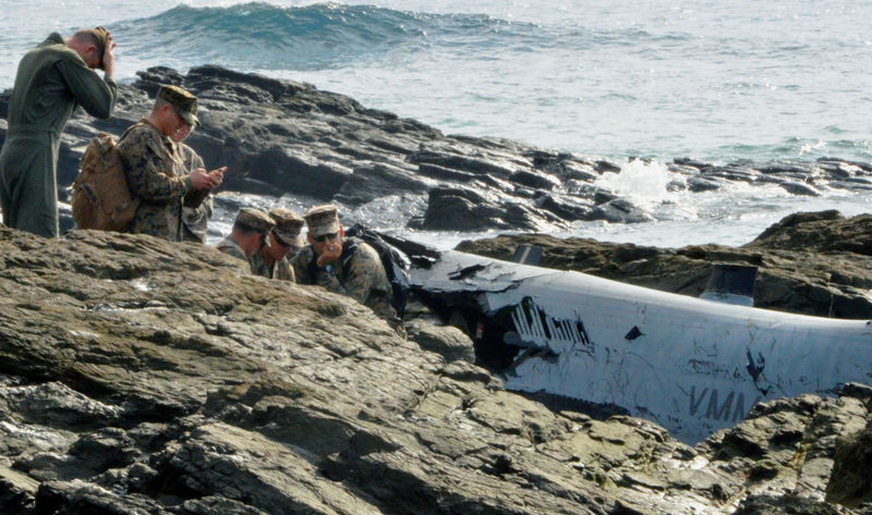 © Reuters. U.S. military personnel investigate the wreckage of a U.S. Marine Corps MV-22 Osprey aircraft that crash-landed in the sea off Nago