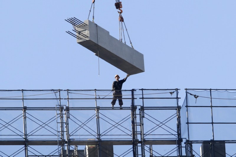 © Reuters. A man works atop of a building constructing site in Tokyo