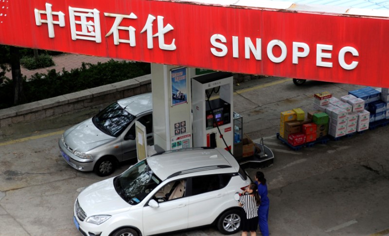 © Reuters. File photo of a customer getting the tank of her car filled at a Sinopec gas station in Qingdao