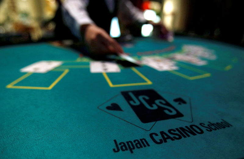 © Reuters. A logo of Japan casino school is seen as a dealer puts cards on a mock black jack casino table during a photo opportunity at an international tourism promotion symposium in Tokyo