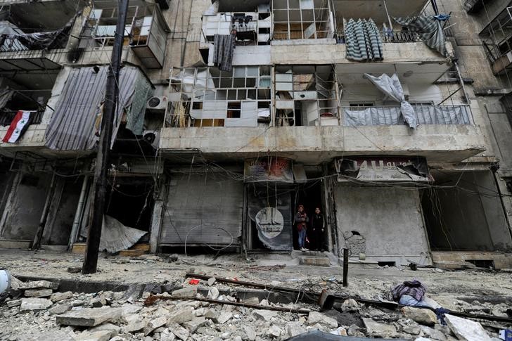 © Reuters. Boys stand amid the damage in the governemnt-held al-Shaar neighborhood of Aleppo