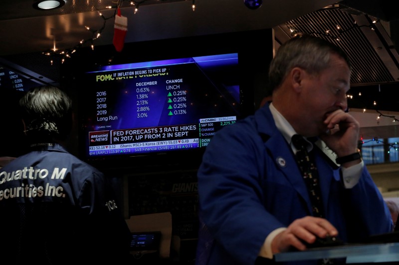 © Reuters. A trader works on the floor of the New York Stock Exchange shortly after the announcement that the U.S. Federal Reserve will hike interest rates in New York