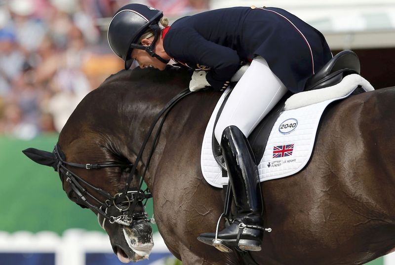 © Reuters. Dujardin celebrates with her horse Valegro during Individual freestyle Competition Dressage at the World Equestrian Games at the d'Ornano stadium in Caen