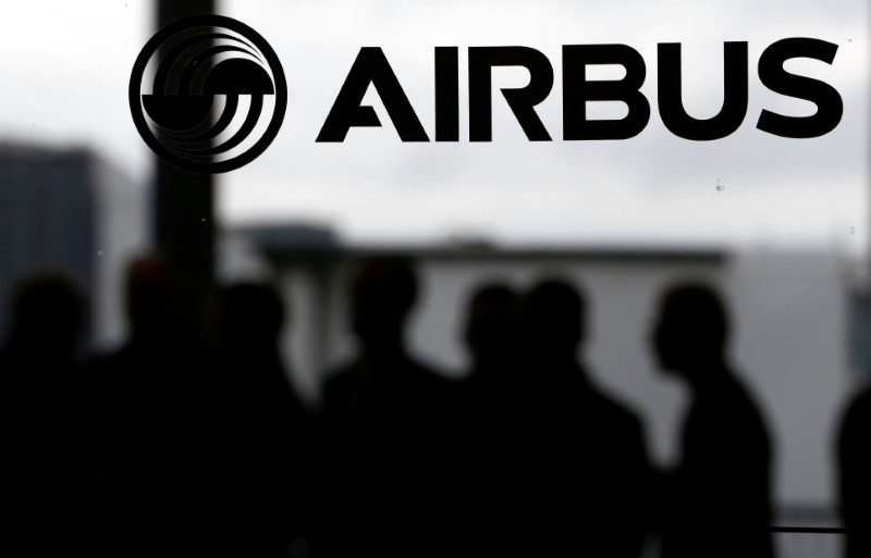 © Reuters. People are seen in silhouette behind the logo of Airbus during the Airbus A350-1000 maiden flight event in Colomiers near Toulouse