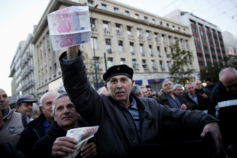 © Reuters. Greek pensioners hold fake euro banknotes during a demonstration against government policies affecting pensioners in Athens