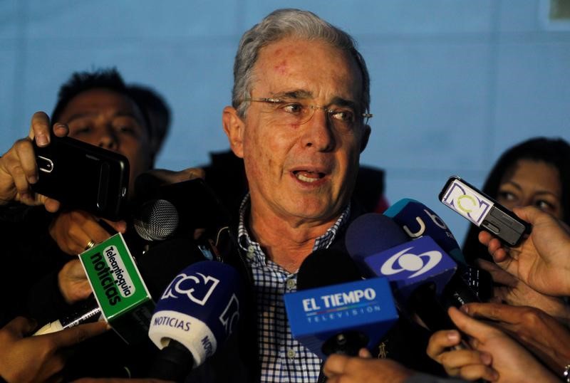 © Reuters. Colombian former president and Senator Alvaro Uribe talks to the media after a meeting with Colombia's President Santos at military air base in Rionegro, Colombia