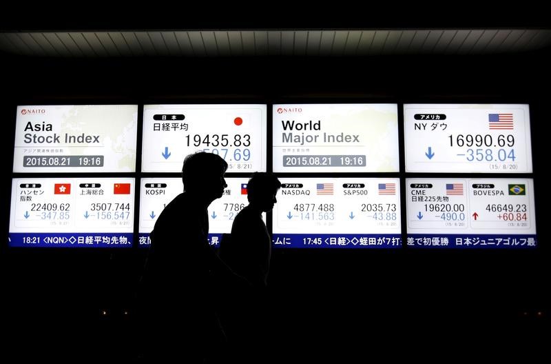 © Reuters. People walk past an electronic board displaying various Asian countries' stock price index and world major index outside a brokerage in Tokyo