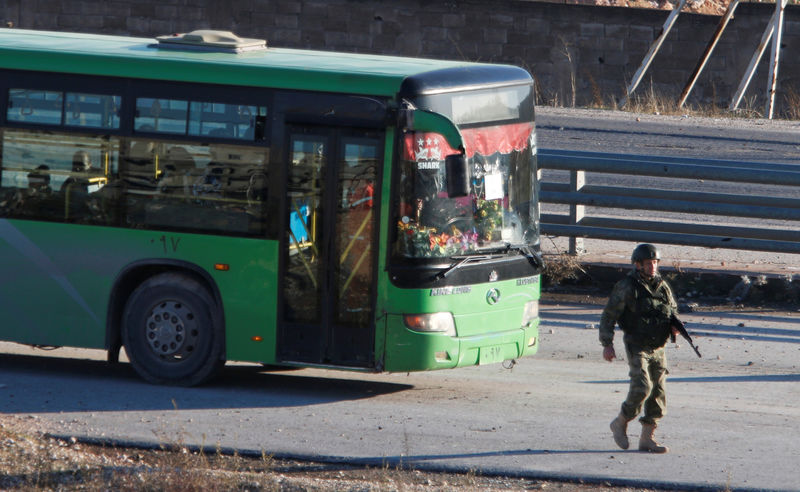 © Reuters. حافلات تجلي الآلاف من سكان حلب بموجب اتفاق لوقف إطلاق النار