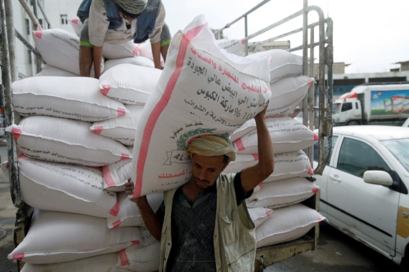 © Reuters. Worker carries a sack of wheat at a store in Sanaa, Yemen