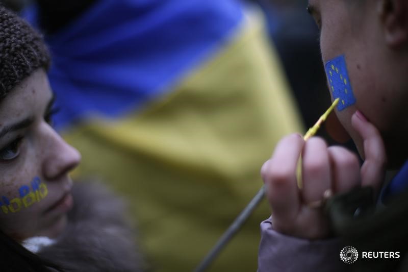 © Reuters. Протестующие раскрашивают лица в цвета флага ЕС в центре Киева