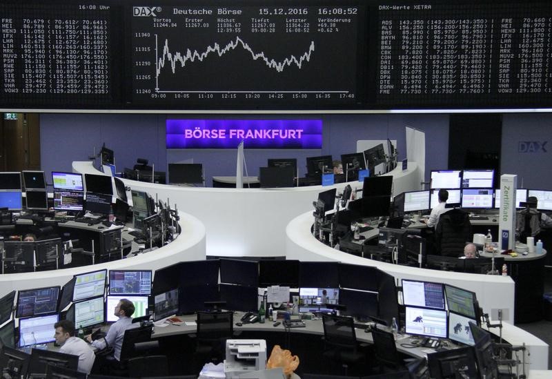 © Reuters. Traders work at their desks in front of the German share price index DAX board in Frankfurt