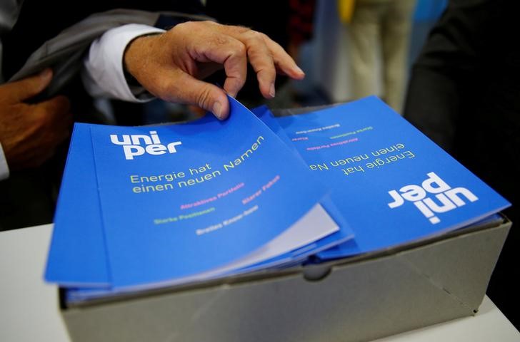 © Reuters. A shareholder of E.ON SE Climate and Renewables picks up a brochure of E.ON's utility sector Uniper SE in Essen