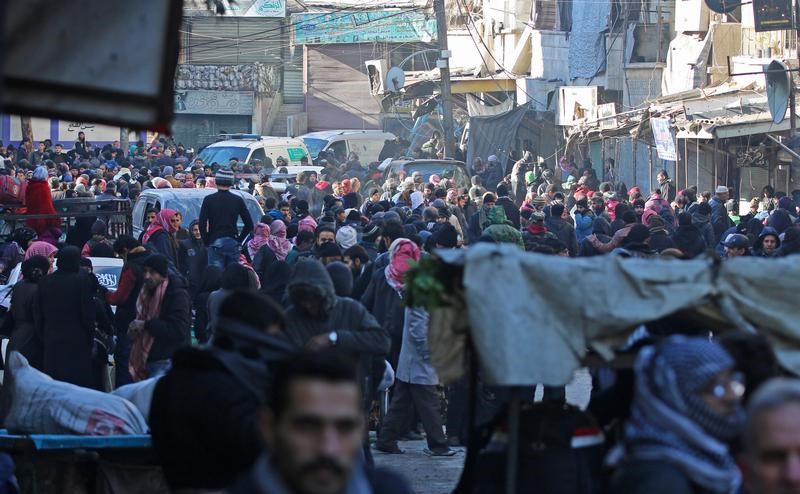 © Reuters. Pessoas aguardam retirada de área tomada por rebeldes no leste da cidade síria de Aleppo