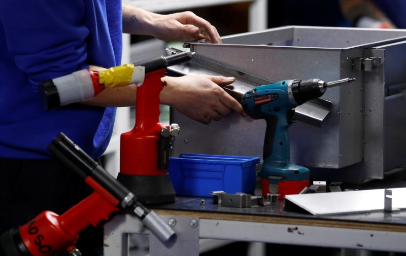 © Reuters. A worker assembles metal components at the Mec Com Ltd factory near Stafford, central England.