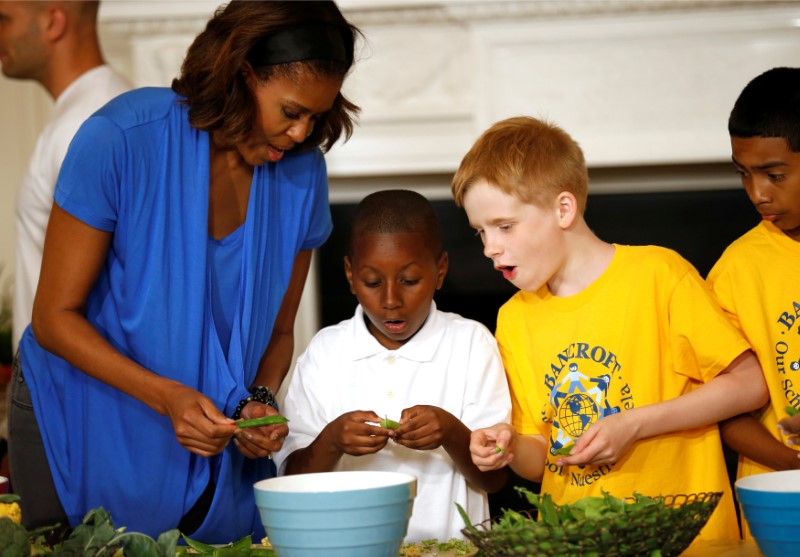 © Reuters. U.S. first lady Obama helps prepare a salad using the summer crop from the White House Kitchen Garden at the White House in Washington