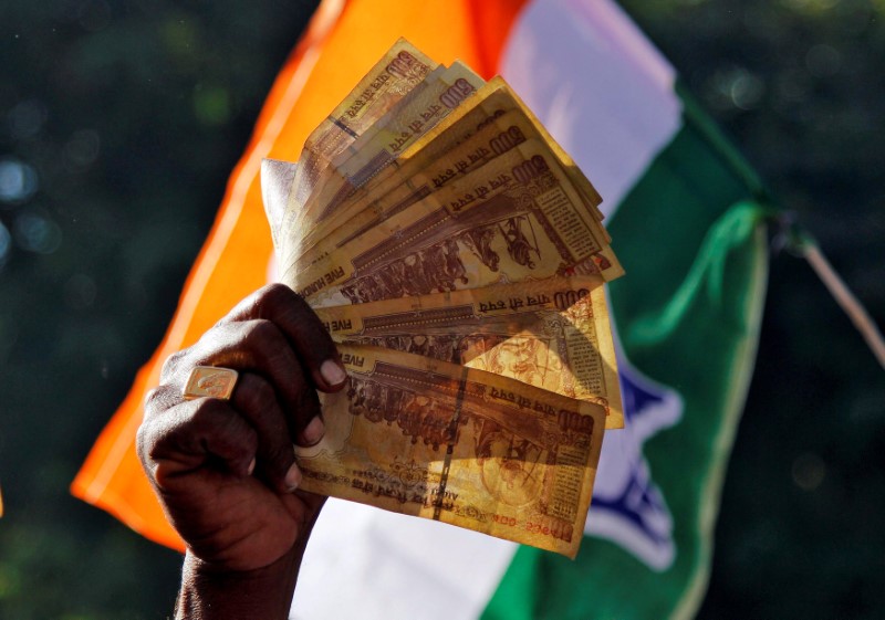 © Reuters. File picture of a man displaying 500 Indian rupee notes during a rally in Ajmer