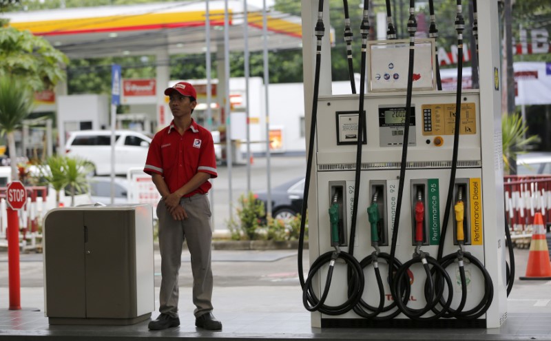 © Reuters. An employee at a Total fuel station waits for customers in south Jakarta