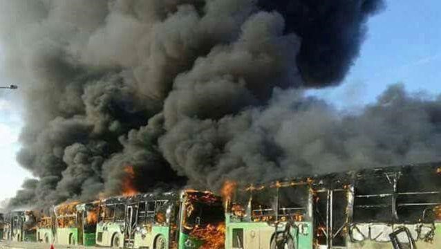© Reuters. مسلحون يحرقون حافلات وقافلة تغادر حلب