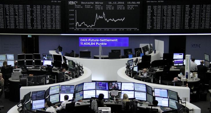 © Reuters. Traders work at their desks in front of the German share price index DAX board in Frankfurt