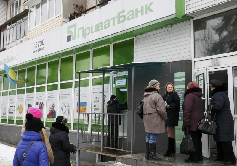 © Reuters. People gather near an automated teller machine outside a PrivatBank branch in Kiev