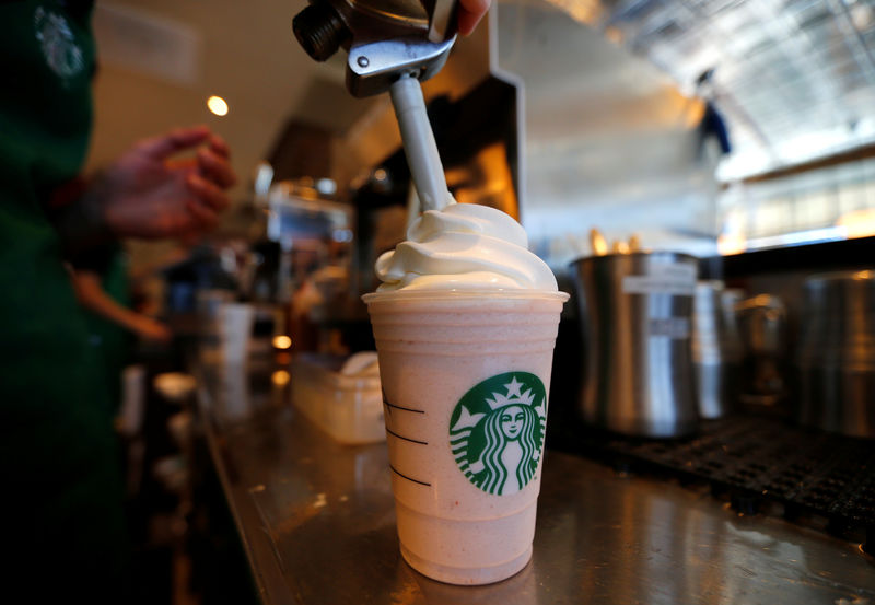 © Reuters. A barista puts whipped cream on a drink at a newly designed Starbucks coffee shop in Fountain Valley, California